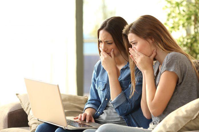 Worried roommates on line with a laptop identity fraud