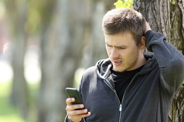 Confused teen reading message in a smart phone Tinder Exposed