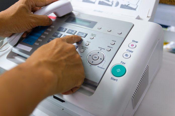 Hand Man are using a fax machine in the office Fax hack