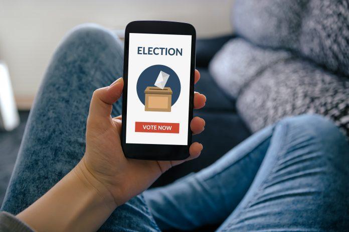 Hand holding smart phone with online voting concept on screen