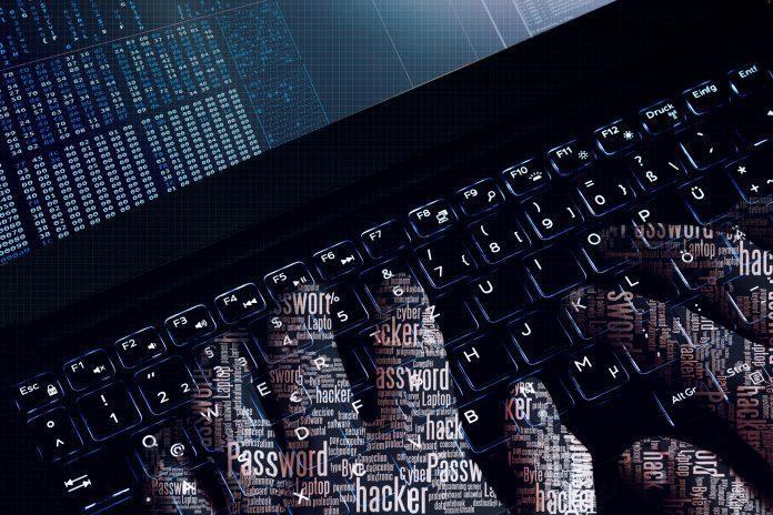 Hacker wordcloud hands at work on a laptop. first person view. German politician hack